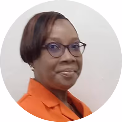 Portrait of a woman with short hair wearing glasses and an orange top against a plain background.